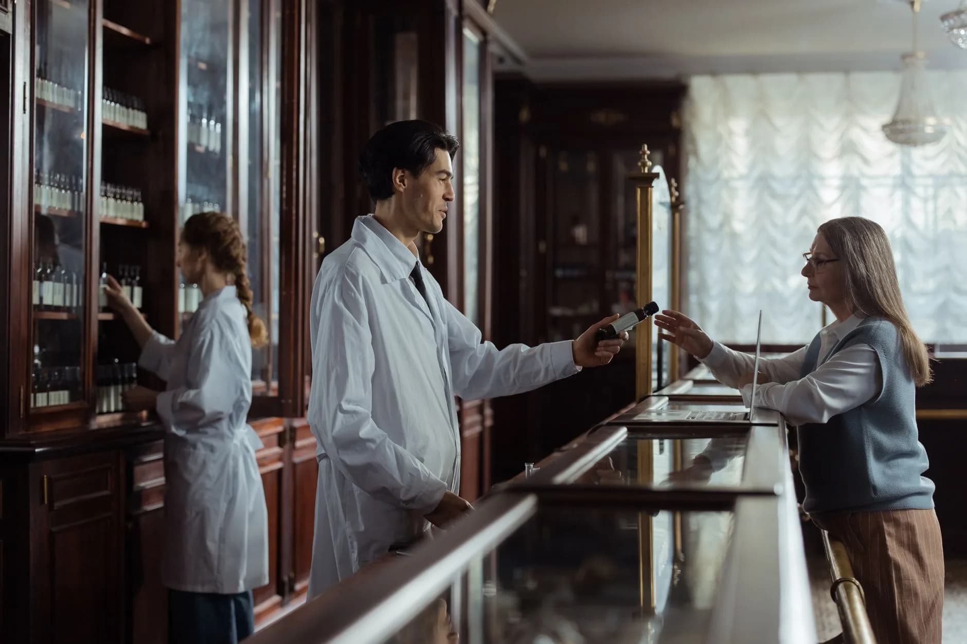 Un farmacista consegna farmaci a un cliente presso un banco di farmacia vintage classico.